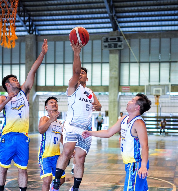  A player from the Civil Engineers-2 Avantrac goes for a layup while being heavily defended by Civil Engineers-1 EGS players in one of the AEBC Sixth Corporate Cup games. | Photo from Ronex Tolin
