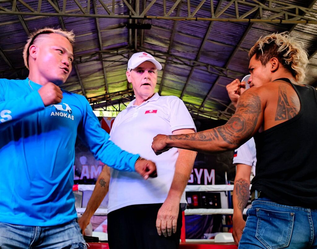 YouTuber amateur slugfest gets solid backing from Money Punch Fight Promotions. In photo are Ryan "Coach Gigil" Illustrisimo (left) and Alex "Boy Tattoo" Legario (right) squaring off while Money Punch Fight Promotions CEO Christian Faust poses in the middle during the presser of "Bakbakan 11" on Thursday, May 18, at the Villamor Boxing Gym. The bout is slated on Saturday, May 20, at the Consolacion sports complex. | Glendale Rosal