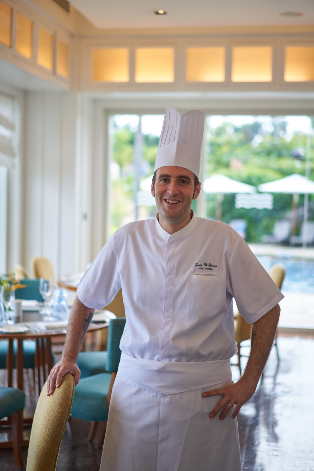 Shangri-La Mactan Cebu’s new Italian Chef, Luca D'Amora poses for a photo at the dining are of Acqua with the view of the pool behind him.
