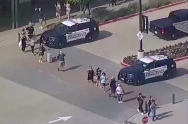 Shoppers leave with hands up as police respond to a shooting in the Dallas area’s Allen Premium Outlets, which authorities said has left multiple people injured in Allen, Texas, U.S., May 6, 2023, in a still image from video. ABC Affiliate WFAA via REUTERS