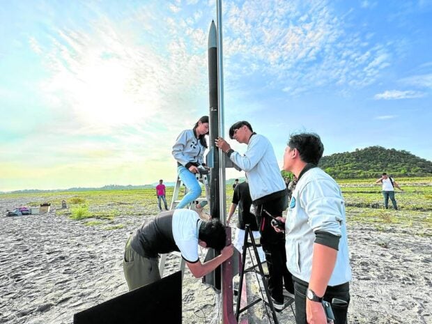 Cebu students launch hybrid rocket, hope more kids reach for stars. ‘AT FIRST, IT WAS JUST FOR FUN’ | Alumni of St. Cecilia’s College in Cebu prepare to launch the TALA in Capas, Tarlac. (Photo from the Philippines Air Force Public Affairs Office)