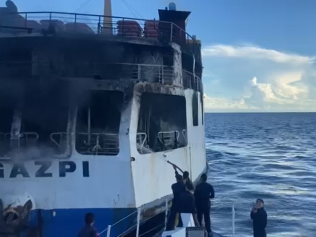 The Philippine Coast Guard Bohol train their hose on the back of the ship, which caught fire early this morning, off the coast of Panglao town in Bohol Province. | PCG photo