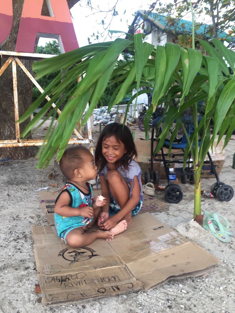 Children play on the sand near the Malapascua Island port. 