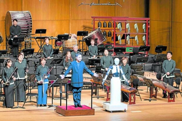 BRAVO! The South Korean-made robot called “EveR 6” (right) and its human maestro face a sellout crowd at the National Theater of Korea in Seoul on June 30. —AFP