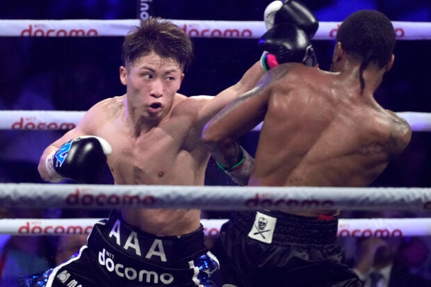 Naoya Inoue, left, of Japan throws a punch against Stephen Fulton of the U.S., during the round seven of a boxing match for the unified WBC and WBO super-bantamweight world titles in Tokyo, Tuesday, July 25, 2023. (AP Photo/Hiro Komae)