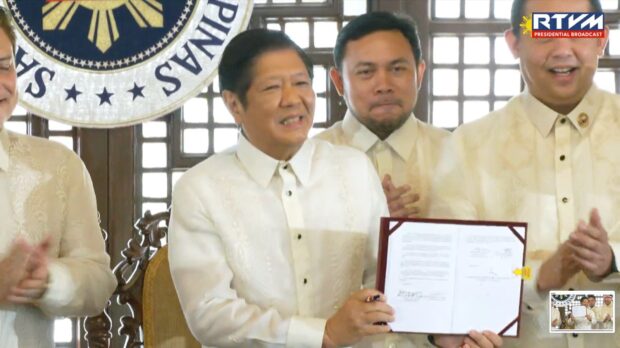 Photo caption: President Ferdinand Marcos Jr. signs the Maharlika Investment Fund bill into law on Tuesday, July 18, 2023. (Photo from RTV Malacañang.)