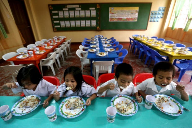 Buwad or salted dried fish, ginamos and noodles are usally the go to food fare for families struggling to make ends meet. In photo are schoolchildren eating malunggay fortified food and iiodized salt.
