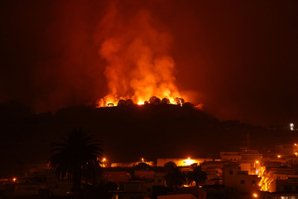 Wildfire in Spain's Tenerife Island. A view shows a fire over the mountains near empty houses after the evacuation in different villages in the north, as wildfires rage out of control on the island of Tenerife, Canary Islands, Spain August 20, 2023. REUTERS/Nacho Doce