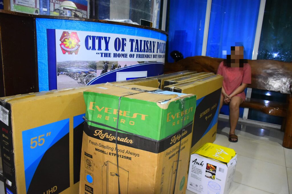 The Talisay police have arrested a "female swindler" (sitting in bench at police station) during a Talisay entrapment operation on Monday, August 28 and retrieved the stolen appliances. | Talisay City Police Station