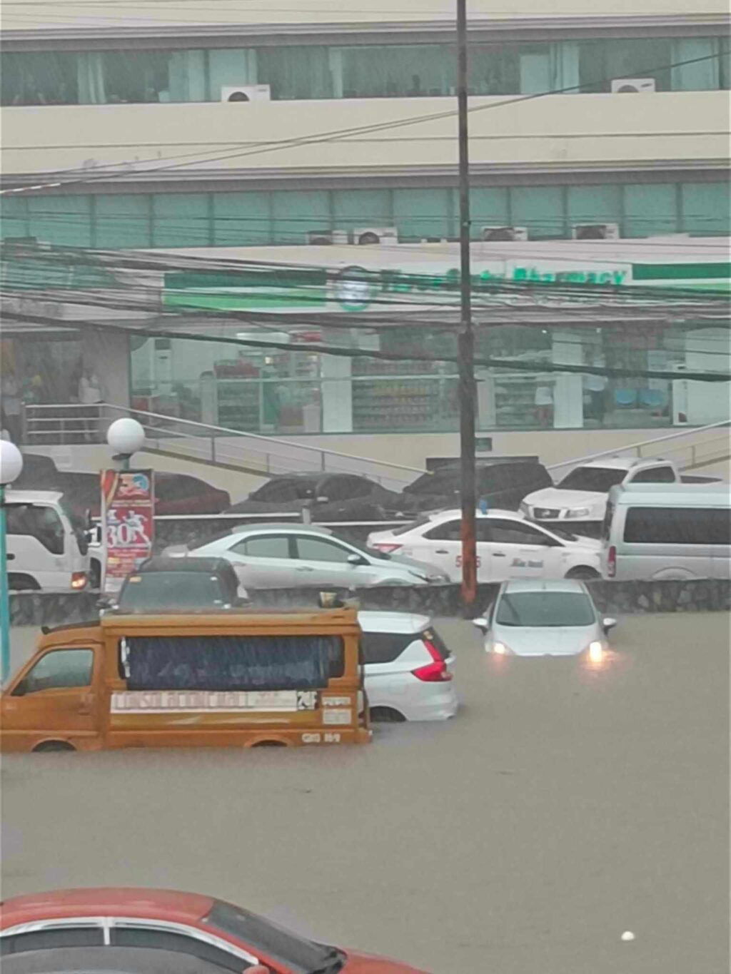 Some vehicles are half submerged in flood waters in a parking lot of an establishment in Barangay Banilad, Cebu City after the heavy rains this afternoon, September 11. | Contributed photo via Paul Lauro