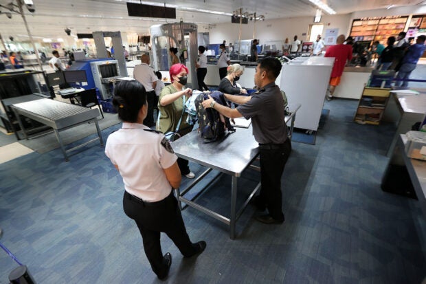 DOTr chief: 19 OTS personnel fired for stealing from airline passengers. Office for Transportation and Security (OTS) personnel inspect the luggage of passengers at the final check area at the Ninoy Aquino International Terminal 1 in Pasay City on Monday, Sept. 25, 2023. (File photo by GRIG C. MONTEGRANDE / Philippine Daily Inquirer)