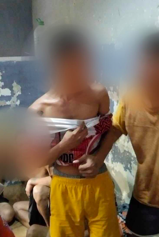 Jealousy over a woman's ex-boyfriend led to mauling of man in Tisa, Cebu City. Angelo Lauza, 21, in yellow shorts, is detained at the Labangon Police Station's detention cell. He is one of the five suspects in the mauling of a man in Barangay Tisa, Cebu City early this morning, September 25. | Labangon Police via Paul Lauro