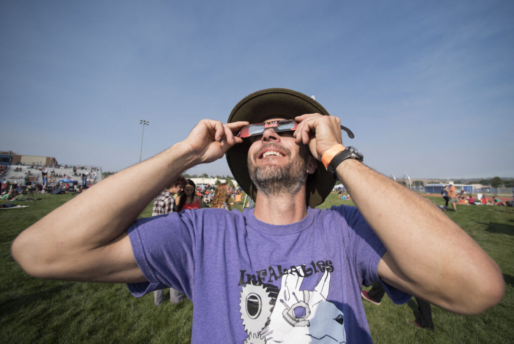 Rich Krueger of the Flagstaff Arts and Leadership Academy views the start of a solar eclipse at the Lowell Observatory Solar Eclipse Experience on August 21, 2017 in Madras, Oregon. Emotional sky-gazers on the US West Coast cheered and applauded Monday as the Sun briefly vanished behind the Moon -- a rare total solar eclipse that will stretch across North America for the first time in nearly a century. (Photo by STAN HONDA / AFP)