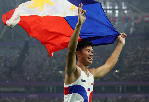 Asian Games – Hangzhou 2022 – Athletics – Olympic Sports Centre Stadium, Hangzhou, China – September 30, 2023 Philippines’ Ernest John Obiena celebrates with the Philippines flag after winning the Men’s Pole Vault Final REUTERS/Jeremy Lee