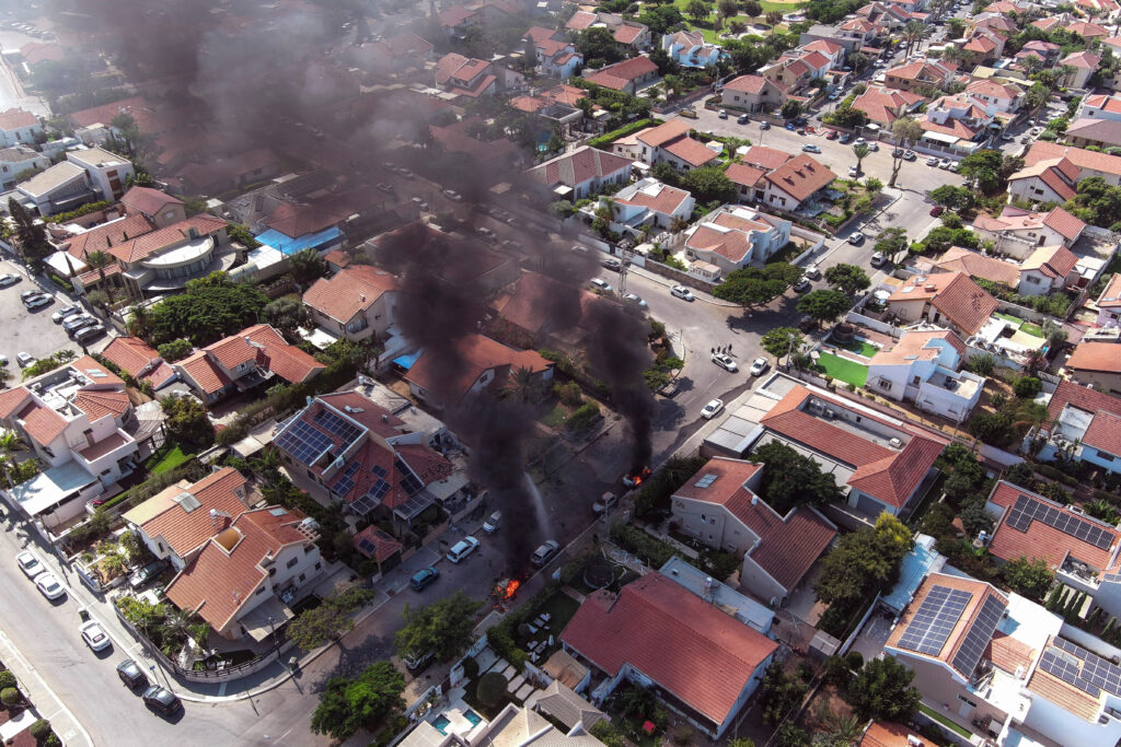 An aerial view shows vehicles on fire as rockets are launched from the Gaza Strip, in Ashkelon, southern Israel October 7, 2023. REUTERS/Ilan Rosenberg