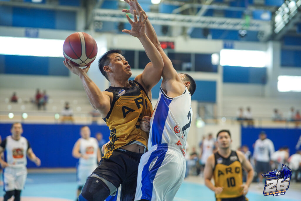 Batch 2001's Mark Hing (yellow jersey) attempts a difficult shot while being heavily defended by Dave Mark Uy (white jersey) of Batch 1994/95/96, in their in their SHAABAA semifinals game. | SHAABAA photo