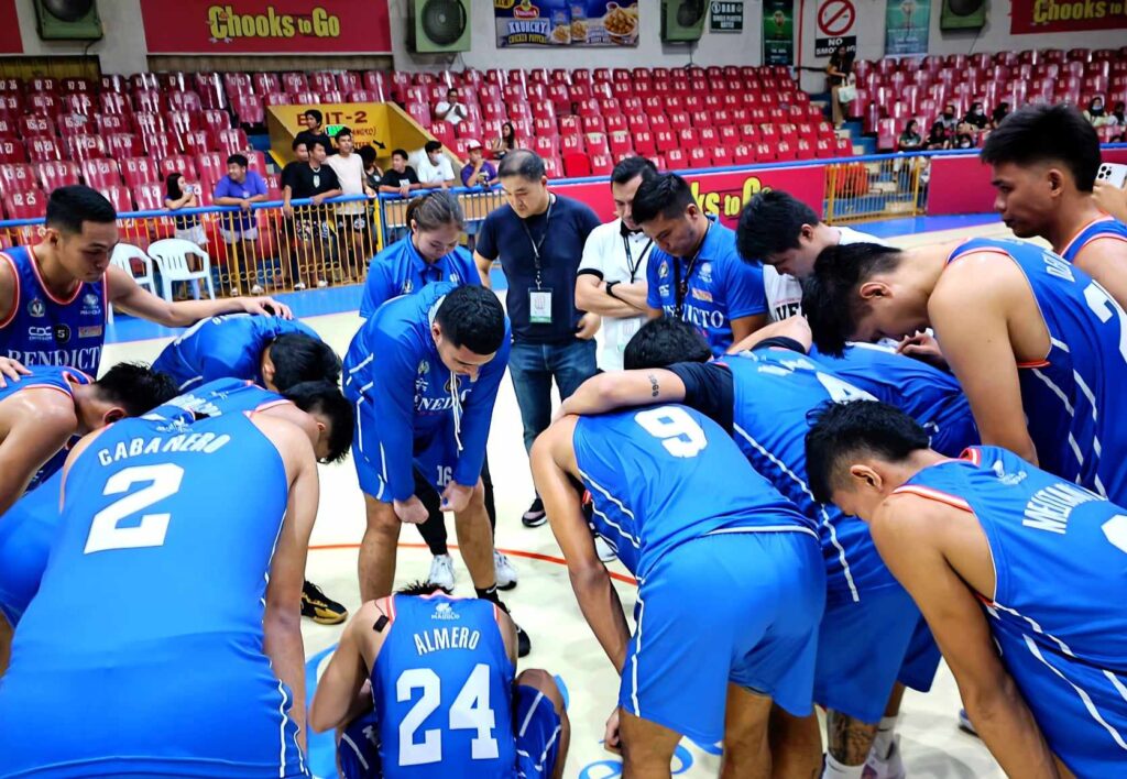 Benedicto College Cheetahs players and coaching staff bow their heads to pray after narrowly beating the CRMC Mustangs. | 📸 : Glendale Rosal