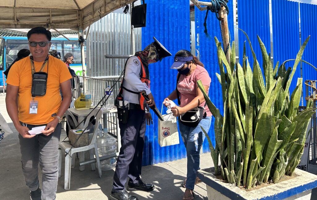 A security guard at the Cebu North Bus Terminal checked, with the use of a metal scanner, the contents of a paper bag brought by a passenger who was traveling on Saturday, October 28, 2023.