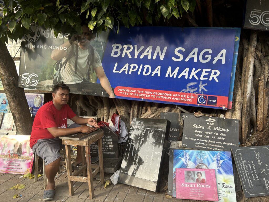 Lapida making: Bryan Saga, Lapida maker, waits for clients at his spot at the Calamba Cemetery in Cebu City. | Niña Mae Oliverio