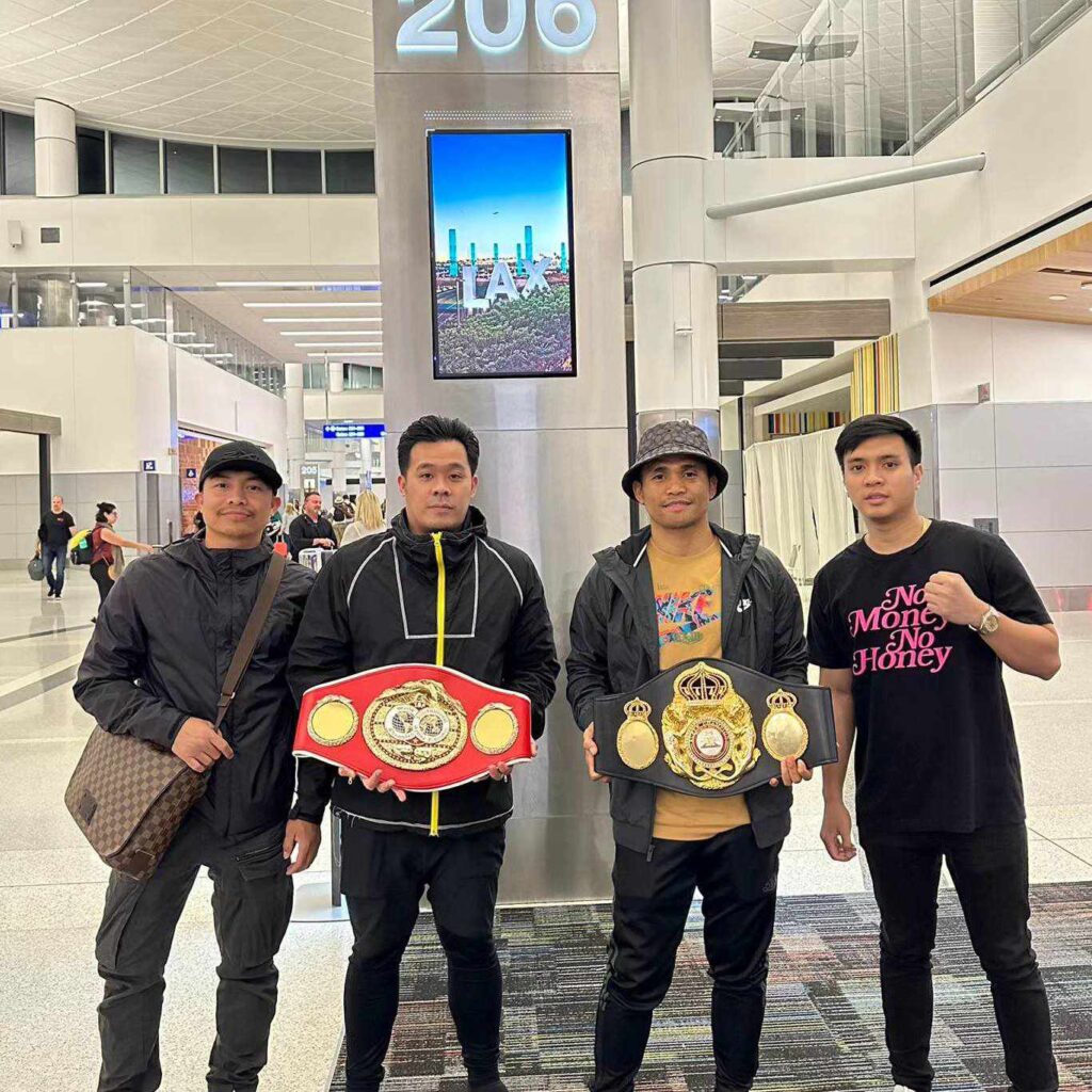 Marlon Tapales (second from left) holds his WBA world title belt alongside Sanman Boxing chief JC Mananquil (holding the WBO) belt and the rest of Team Tapales at the LAX prior to their flight back to the Philippines.