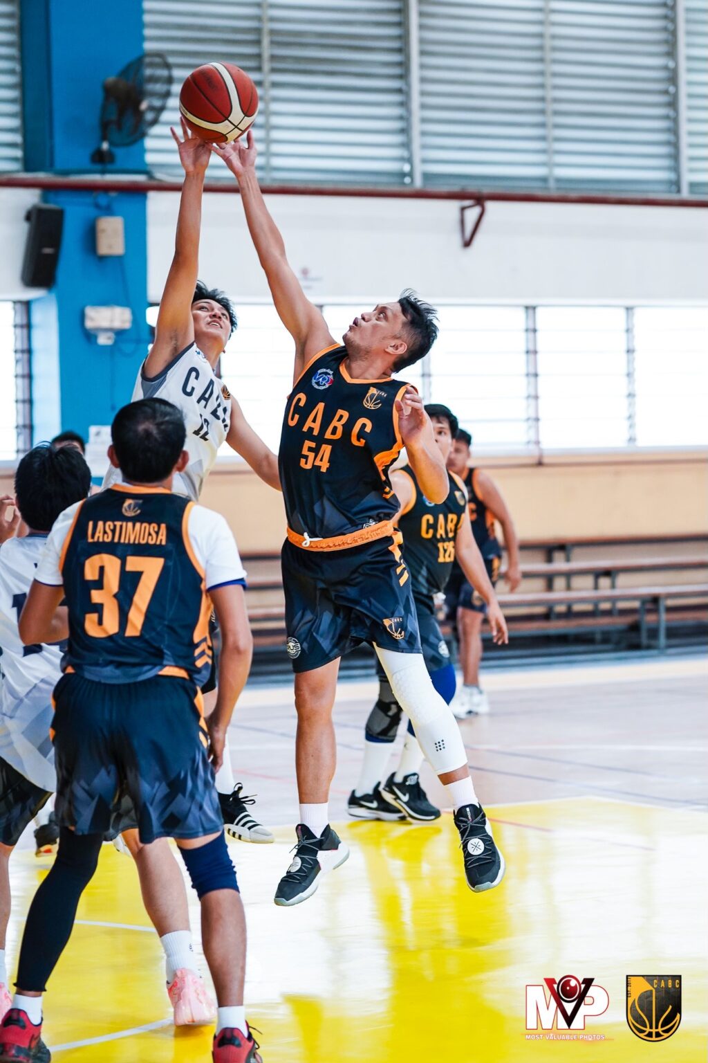 Players from Titan (white jersey) and Virtuoso (dark jersey) battle for a rebound in their Cebu Architects Basketball Club (CABC) Boysen Cup 2023 game.