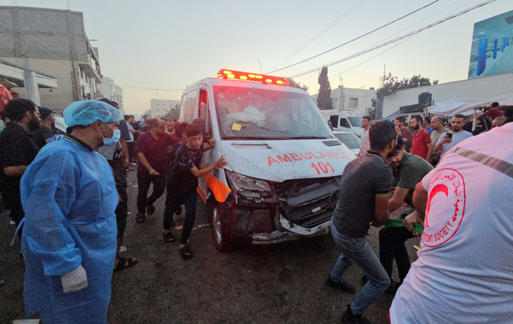 Palestinians pull an ambulance after a convoy of ambulances was hit, at the entrance of Shifa hospital in Gaza City, November 3, 2023. REUTERS/Anas al-Shareef