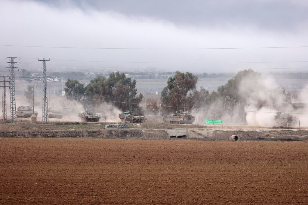 A picture taken from southern Israel near the border with the Gaza Strip shows Israeli armoured vehicles returning from the Palestinian territory on December 10, 2023, amid ongoing battles with the Palestinian Hamas group. (Photo by GIL COHEN-MAGEN / AFP)