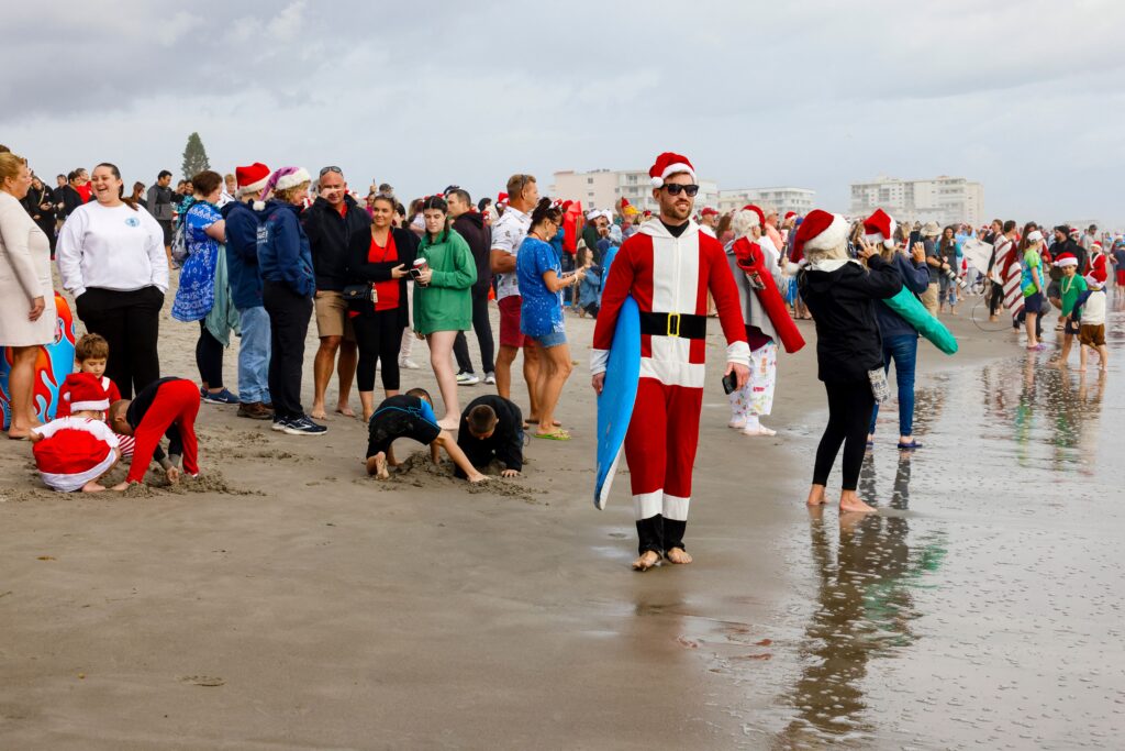Surfing Santas ride waves in Florida: A surfer dressed as Santa carries a surfboard during the 15th annual “Surfing Santas” event in Cocoa Beach, Florida, on December 24, 2023. (Photo by Eva Marie UZCATEGUI / AFP)