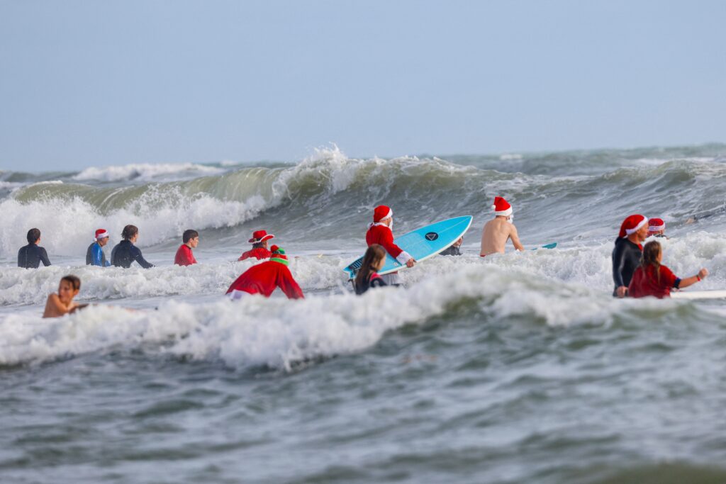 Surfing Santas ride waves, raise funds in Florida. In photo are Surfers dressed as Santa go into the water to ride waves during the 15th annual “Surfing Santas” event in Cocoa Beach, Florida, on December 24, 2023. (Photo by Eva Marie UZCATEGUI / AFP)
