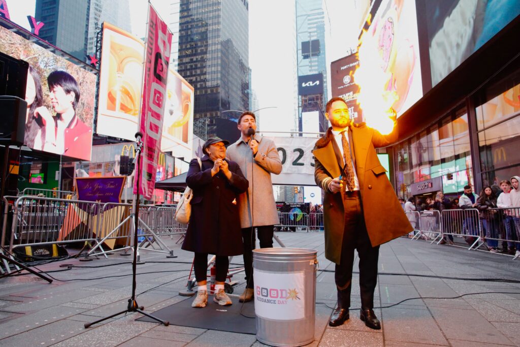 2023 problems, peeves given symbolic farewell. In photo is a magician burning a note written by a woman as people gather to rip up bad memories during the annual Times Square Good Riddance Day in New York on December 28, 2023. Good Riddance Day is inspired by a Latin American tradition in which New Year's revellers stuff dolls with objects representing bad memories before setting them on fire. (Photo by Kena Betancur / AFP)