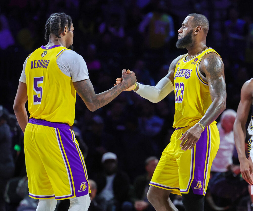 Lakers Cam Reddish #5 and LeBron James #23 of the Los Angeles Lakers shake hands as James checks out late in the fourth quarter of the championship game of the inaugural NBA In-Season Tournament at T-Mobile Arena on December 09, 2023 in Las Vegas, Nevada. The Lakers defeated the Pacers 123-109. |  Ethan Miller/Getty Images/AFP