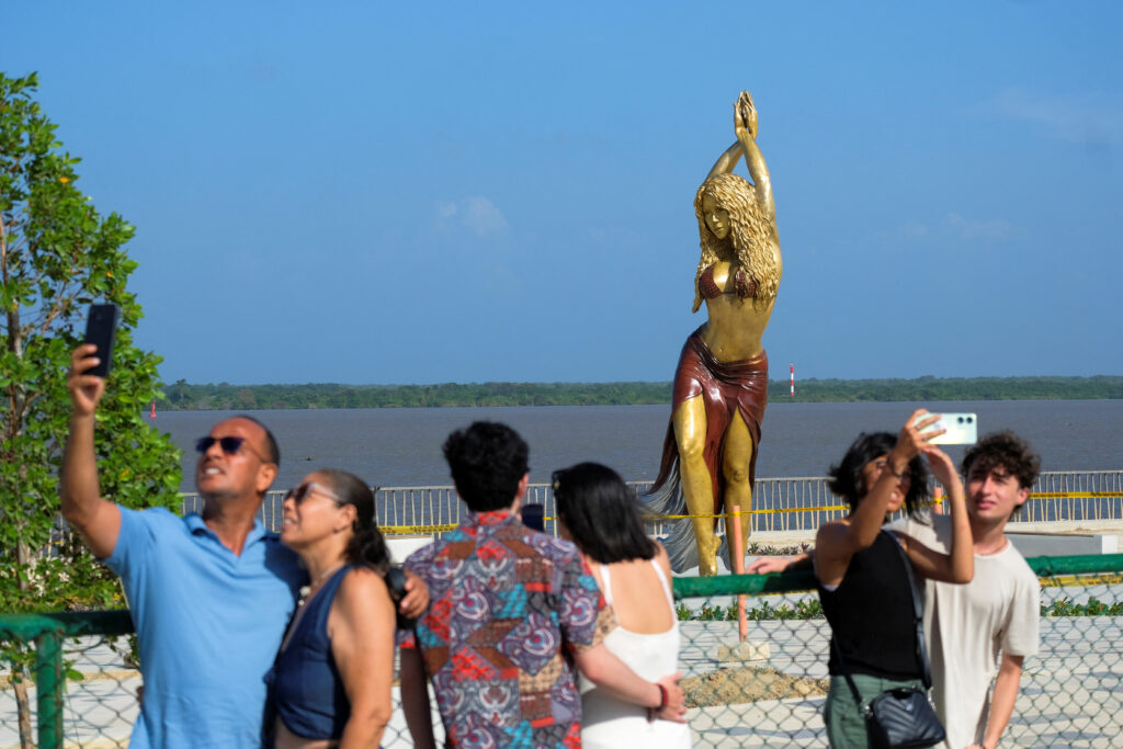 People pose for photos next to the statue of Colombian singer Shakira at the Gran Malecon in Barranquilla, in Barranquilla, Colombia, December 27, 2023. REUTERS/Carlos Parra Rios