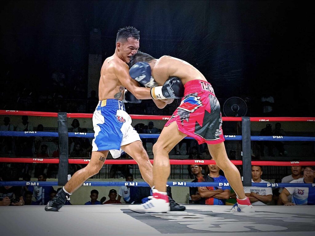Amparo will bounce back, become champion one day, says PMI chief. In photo is Jake Amparo (blue/white trunks) landing a right uppercut to Pedro Taduran's midsection during their IBF world minimumweight title eliminator. | Glendale Rosal
