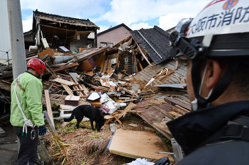 Japan quake update: Under rubble, hopes fade for survivors. In photo is a rescue dog helping firefighters search for people in the rubble of collapsed houses in Wajima, Ishikawa prefecture on January 4.
