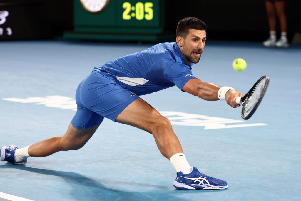 Serbia's Novak Djokovic hits a return shot against Australia's Alexei Popyrin during their men's singles match on day four of the Australian Open tennis tournament in Melbourne on January 17, 2024. | AFP
