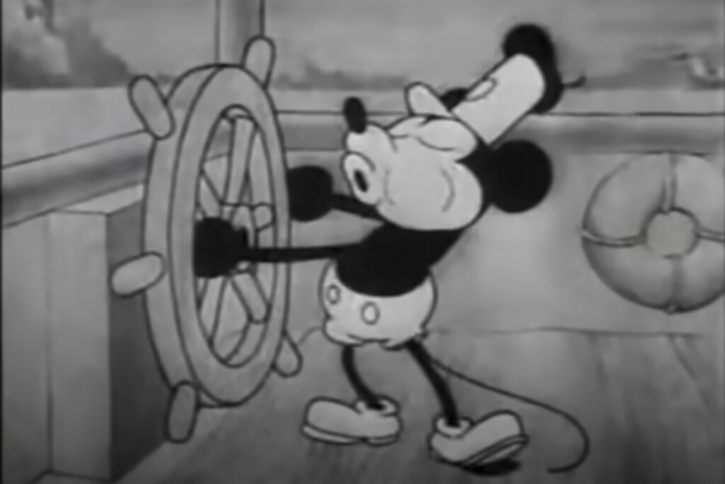 Mickey Mouse stars in "Steamboat Willie." This still image from video provided by Disney shows the character Mickey Mouse in the 1928 animated short "Steamboat Willie." On Monday, Jan. 1, 2024, the iconic character from “Steamboat Willie” entered the public domain after the expiration of the 95-year copyright, and is already the focus of two horror films. (Disney via AP)