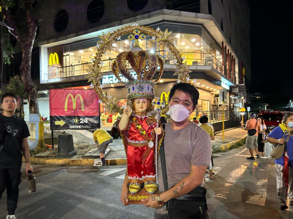 Walk With Jesus. A devotee carries the image of the Sto. Nino as he joins the procession from Fuente Osmena to the Basilica. | Christian Dave Cuizon