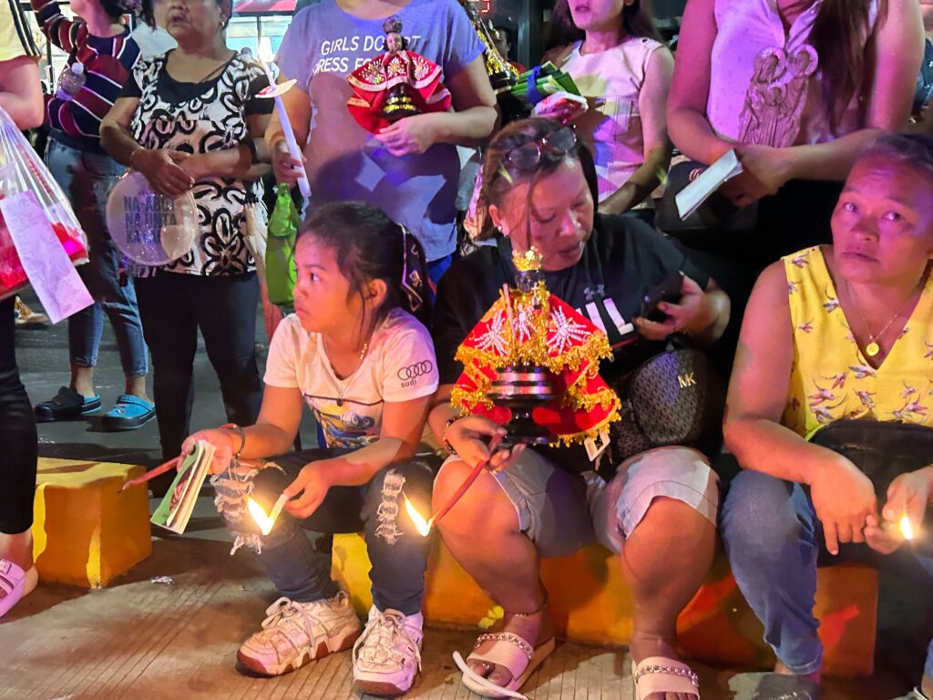 'Walk with Jesus': Some of the devotees sit at the sidewalk as they wait for the procession to pass by and for them to join the walk to the Basilica Minore del Sto. Nino where the opening salvo Mass of the Fiesta Senor will be held. | Nina Mae Oliverio
