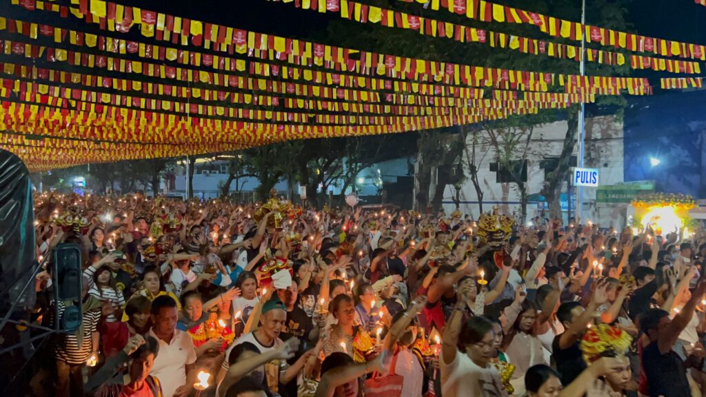Walk with Jesus: Devotees wave their hands and raise their images of the Holy Child as the Bato Balani sa Gugma is played during the procession. | Nina Mae Oliverio