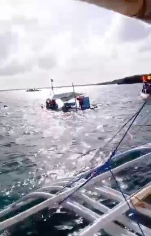 Motor banca sinks during fluvial procession. A small pumpboat sinks along the Mactan Channel as during the fluvial procession. | Screen grab from contributed video
