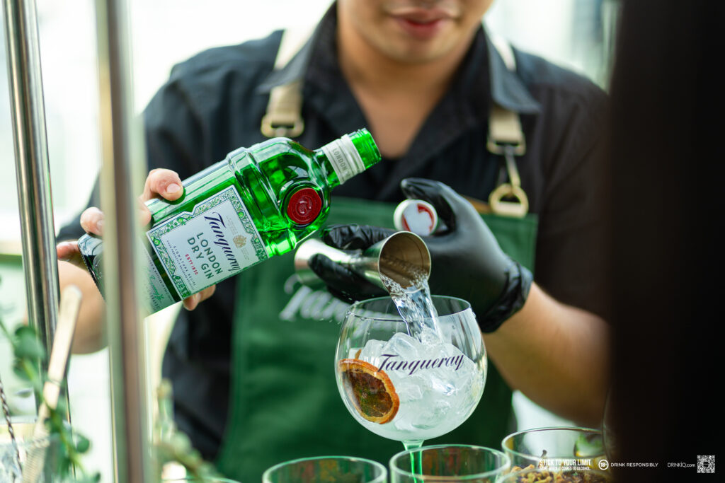 Bartender uses Tanqueray and Tonics for the cold beverage