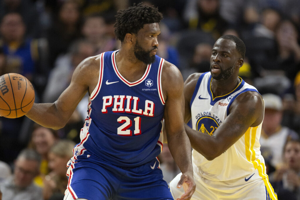 NBA: Philadelphia 76ers center Joel Embiid (21) looks to pass around Golden State Warriors forward Draymond Green (23) during the second half of an NBA basketball game, Tuesday, Jan. 30, 2024, in San Francisco. (AP Photo/D. Ross Cameron)