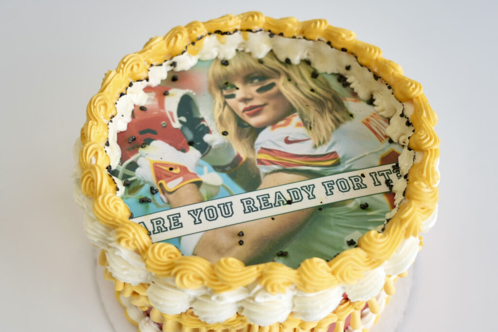 Taylor Swift, Trevor Kelce gear flies off shelves: In photo is a Taylor Swift-themed "burn away cake" being displayed in Coon Rapids, Minn., Monday, Feb. 5, 2024. Maddie Schmitz, owner of Something Sweet by Maddie Lu, created the Swift/Travis Kelce cakes just in time for NFL football's upcoming Super Bowl. | AP