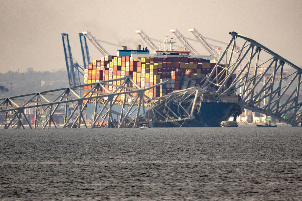 Baltimore Bridge collapse: Part of the steel frame of the Francis Scott Key Bridge sits on top of the container ship Dali after the bridge collapsed in Baltimore, Maryland, on March 26, 2024. Dali struck the bridge sending multiple vehicles, people into the frigid harbor below. Photo by Kent Nishimura / AFP