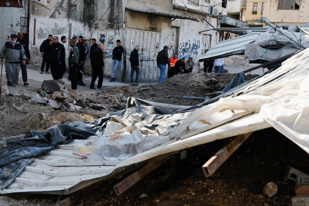 People gather near damages, in the aftermath of an Israeli raid, at Nour Shams camp, in Tulkarm, in the Israeli-occupied West Bank March 21, 2024. REUTERS/Raneen Sawafta