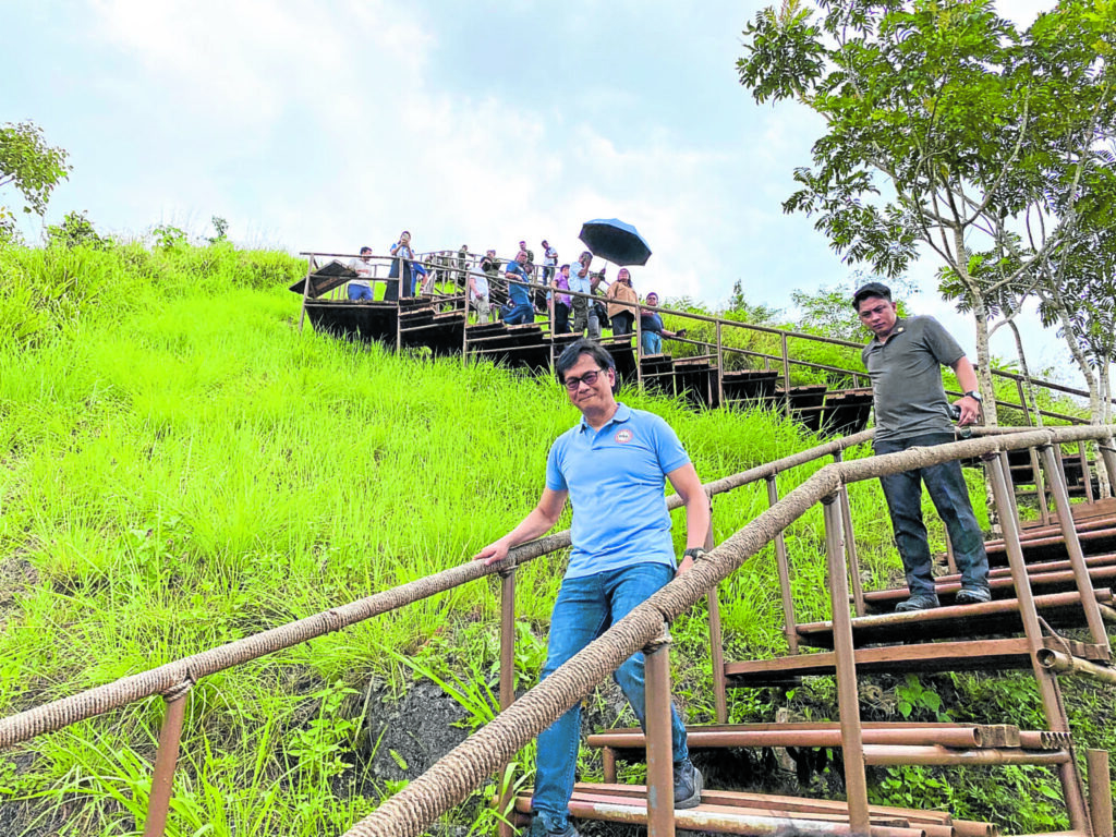 Interior and Local Government Secretary Benhur Abalos, who is part of a government team inspecting illegal structures built within the Chocolate Hills in Bohol on Thursday, climbs a hill through a stairway built at Bud Agta viewing deck in Carmen town.
