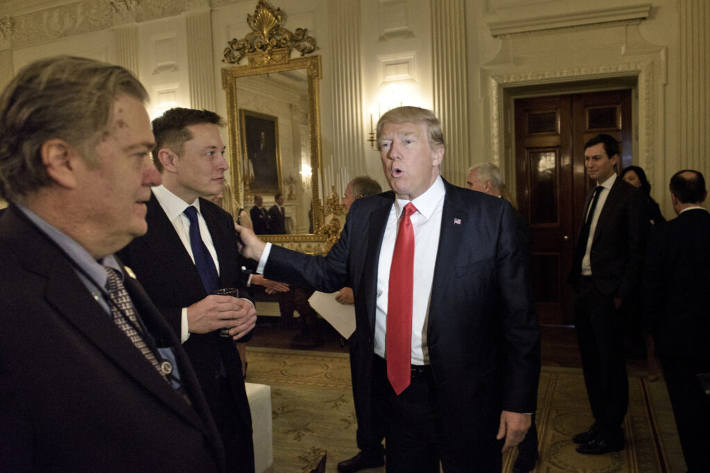 Trump Musk: Trump advisor Steve Bannon (L) watches as US President Donald Trump greets Elon Musk, SpaceX and Tesla CEO, before a policy and strategy forum with executives in the State Dining Room of the White House February 3, 2017 in Washington, DC. (Photo by Brendan Smialowski / AFP)