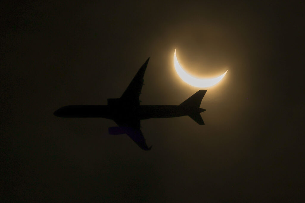 Solar Eclipse: An airplane flies in the path of a partial solar eclipse while seen from Glen Rock on April 08, 2024 in Glen Rock, New Jersey. | AFP