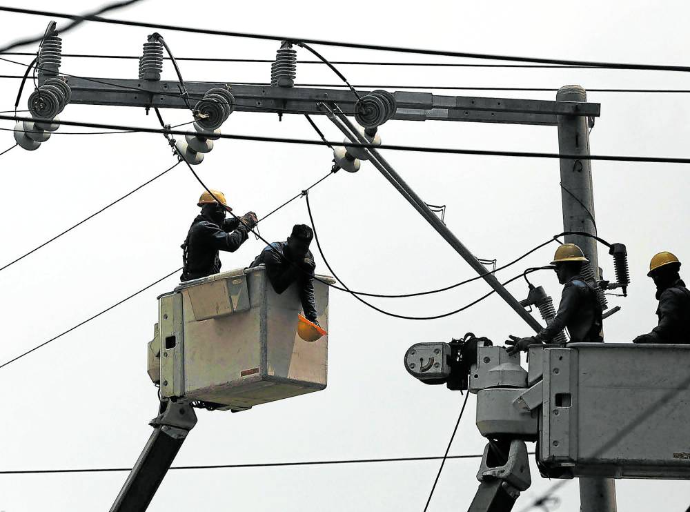 Linemen replace cable on electric posts.