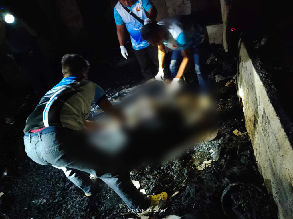 Responders carry a body bag containing the charred remains of a 36-year-old woman who was burned to death when her home caught fire in Tubod Dugoan, Dumanjug, Cebu late Sunday night, March 31.